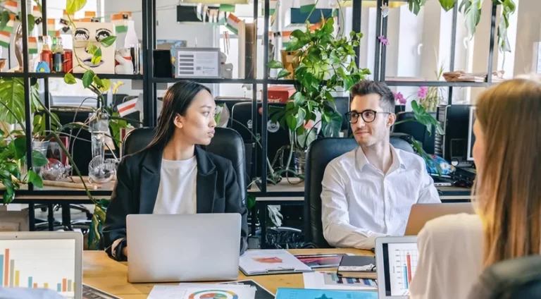 Riunione di lavoro in ufficio con computer e report stampati sul tavolo, la digitalizzazione dei processi in una PMI
