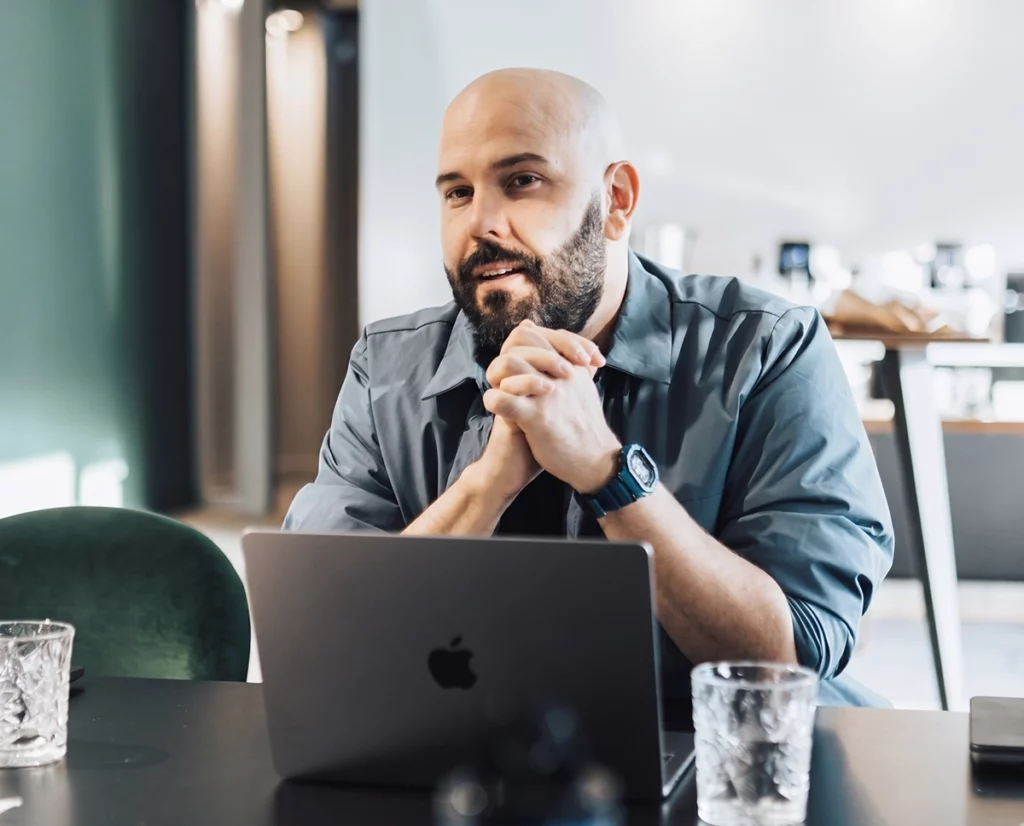 Uomo con la barba al computer portatile in uno spazio di lavoro, l'azienda che lavora su un'unica piattaforma