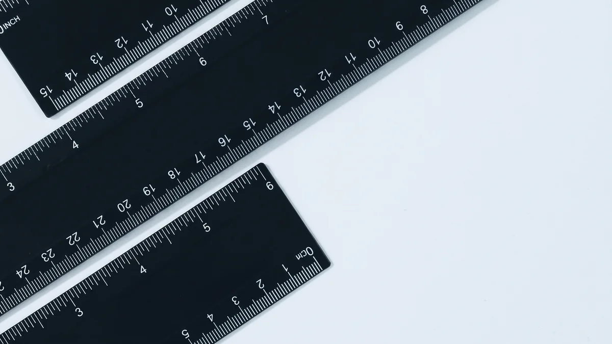Tre righelli neri in pollici e centimetri su fondo chiaro